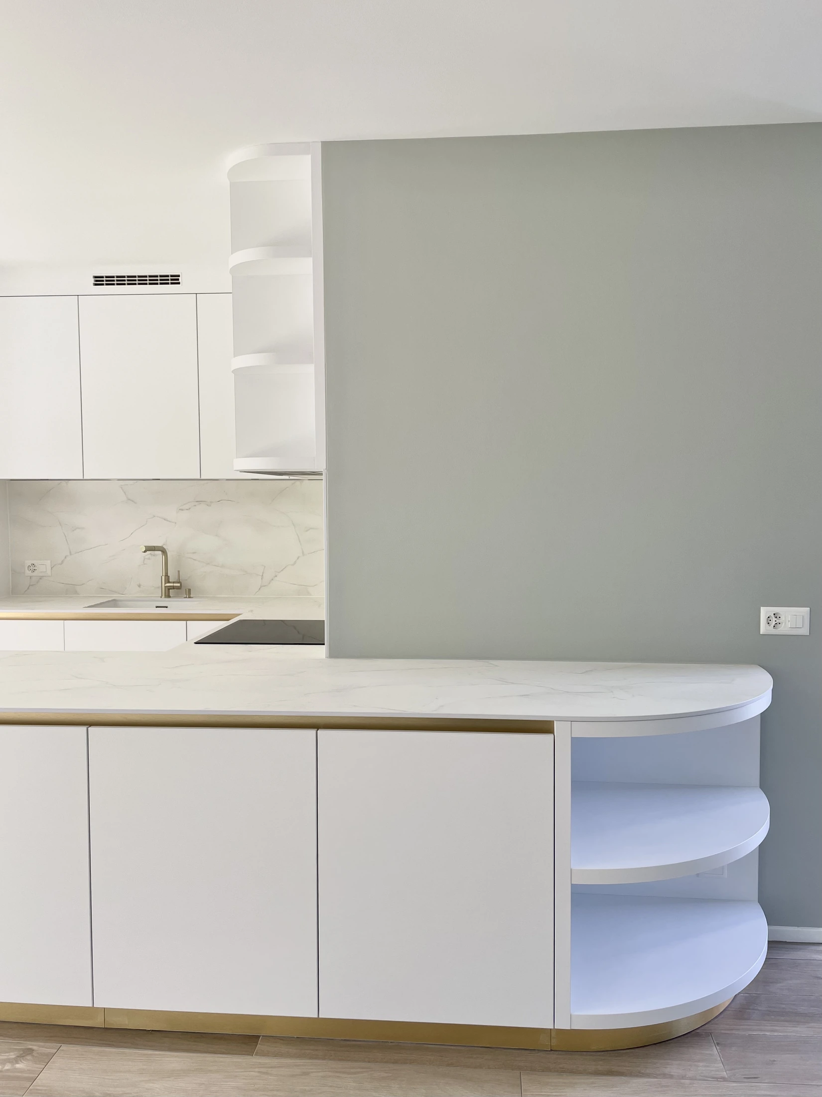 Cuisine blanche aux finitions dorées et étagères arrondies, réalisée par l’Atelier des Rocailles